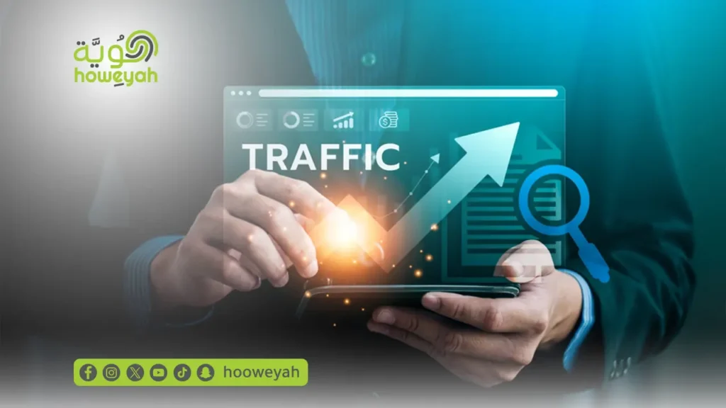 شخص يمسك جهازاً لوحياً يعرض رسماً بيانياً صاعداً لكلمة TRAFFIC مع شعار شركة هوية.